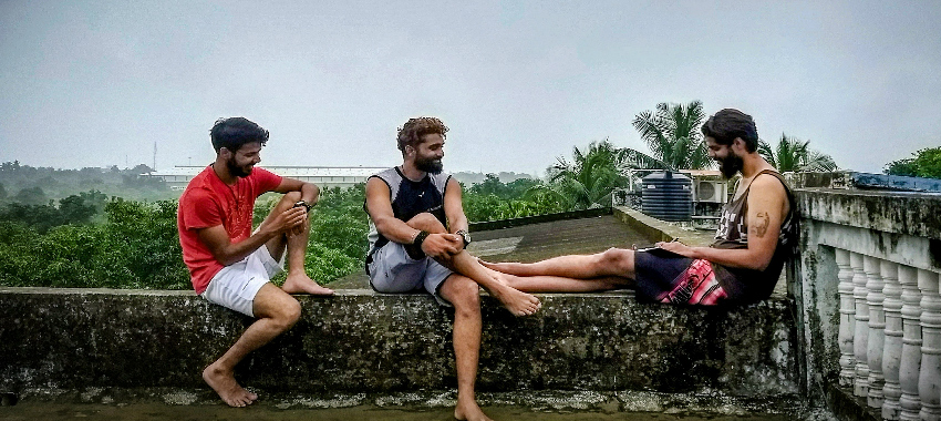 3 men sitting on roof
